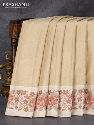 Tussar silk saree beige and cream with allover zari buttas and floral design cross stitched embroidery border
