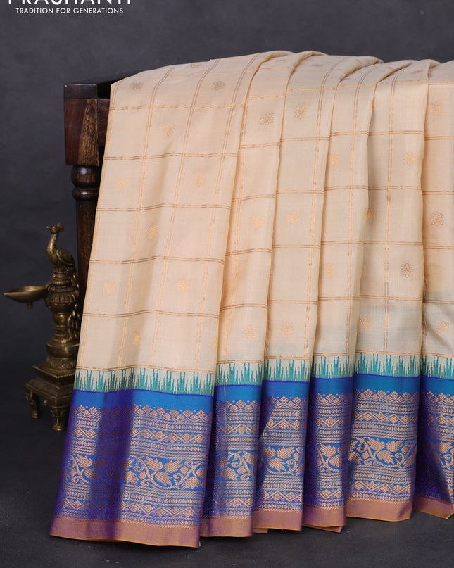 Pure gadwal silk saree cream and dual shade of blue with allover zari checks & buttas and temple design zari woven korvai border
