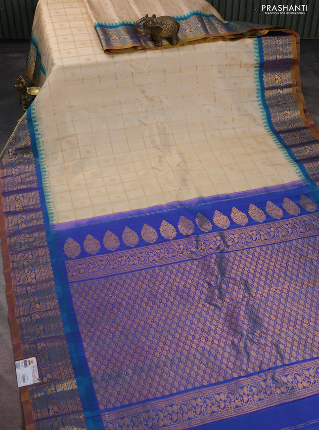Pure gadwal silk saree cream and dual shade of blue with allover zari checks & buttas and temple design zari woven korvai border