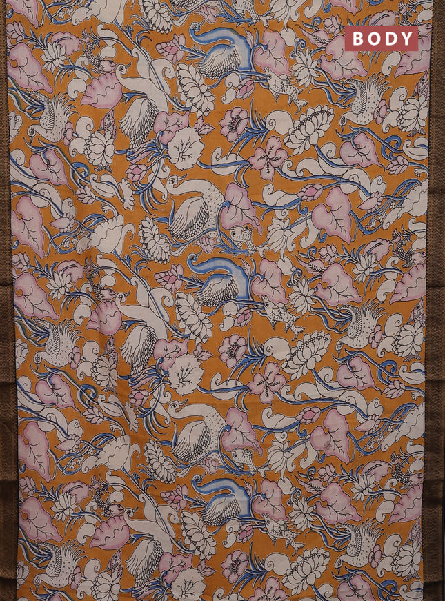 Kalamkari semi silk saree dark mustard and black with allover prints and zari woven border