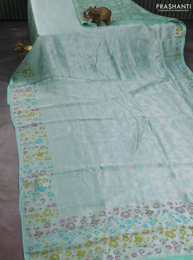 Banarasi semi raw silk saree teal green with allover silver zari woven floral weaves and floral design paithani border