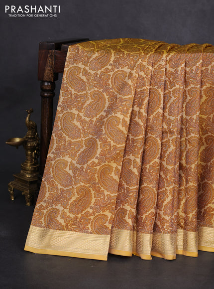 Printed silk saree pale yellow with allover paisley prints and zari woven border