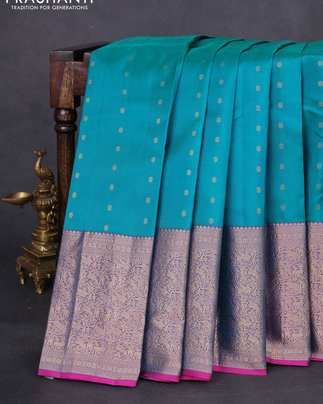 Pure kanchipuram silk saree dual shade of teal bluish green and dual shade of purple with allover zari woven buttas and long zari woven korvai border