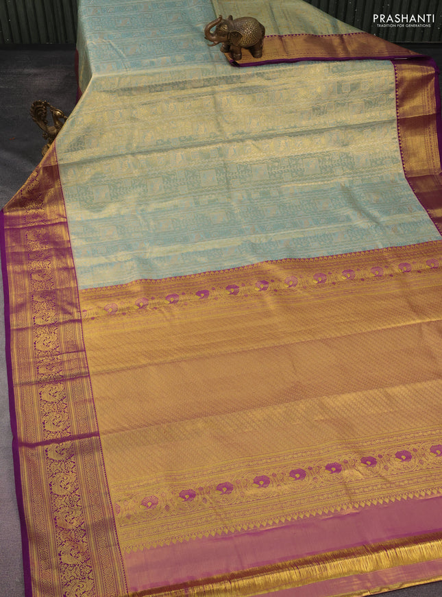 Kanchipuram tissue silk saree dual shade of teal blue and purple with allover zari woven brocade weaves and rich zari woven border