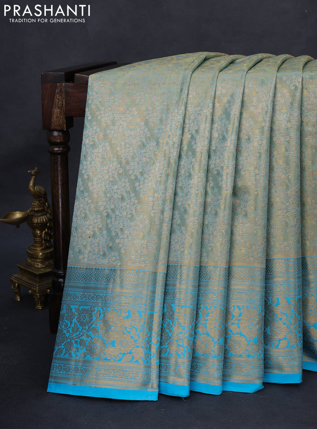 Kanchipuram tissue silk saree dual sahde of teal blue with allover zari woven brocade weaves and long rich zari woven floral border