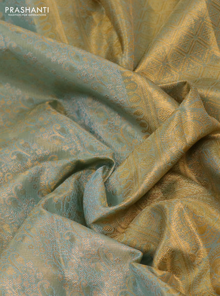 Kanchipuram tissue silk saree dual sahde of teal blue with allover zari woven brocade weaves and long rich zari woven floral border