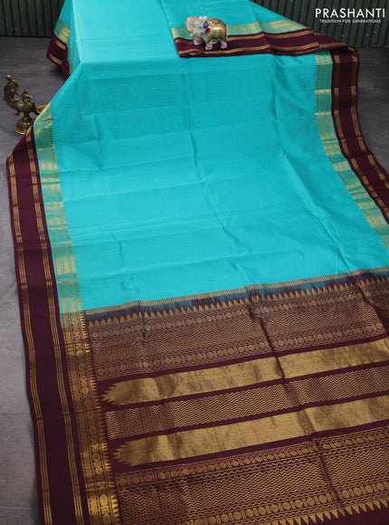 Silk cotton saree teal blue and deep wine with plain body and zari woven simple border