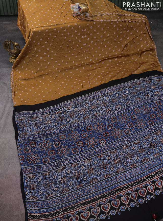 Modal silk saree dark mustard and black with allover bandhini prints and ajrakh printed pallu & blouse