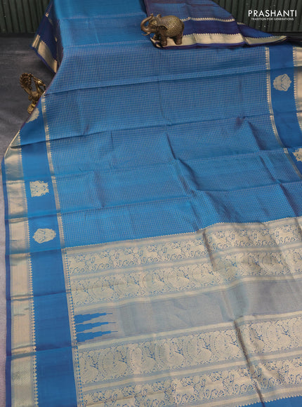 Pure kanchipuram silk saree dual shade of peacock blue with allover zari woven checked pattern and rettapet zari woven butta border