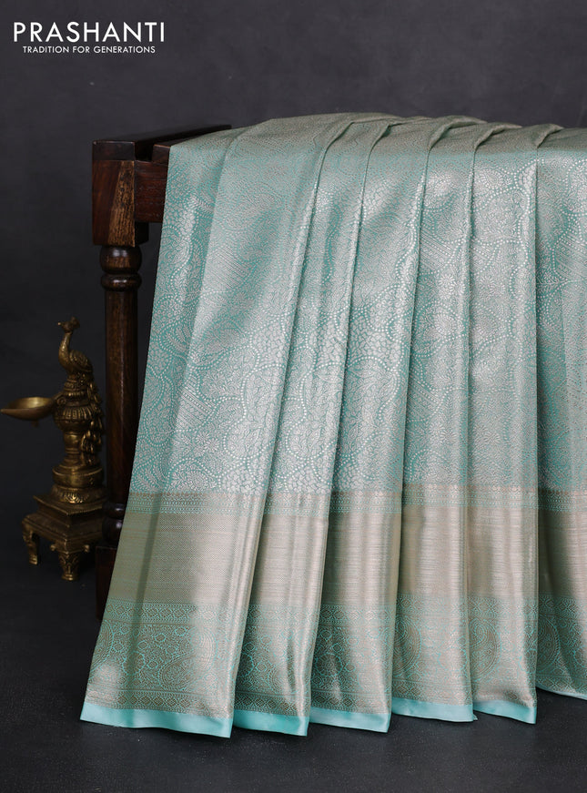Semi kanchipuram tissue silk saree teal shade with allover silver zari woven brocade weaves and long zari woven border