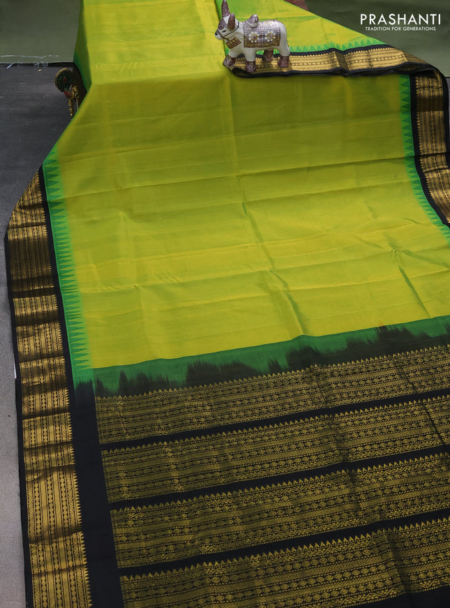 Silk cotton saree light green and black with plain body and temple design zari woven korvai border