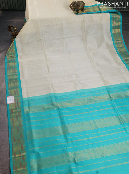 Silk cotton saree cream and teal blue with plain body and zari woven korvai border