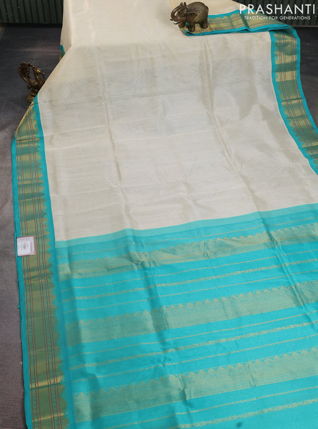 Silk cotton saree cream and teal blue with plain body and zari woven korvai border