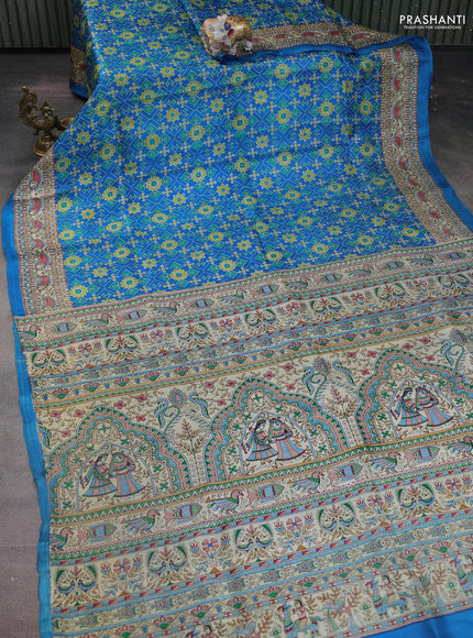 Printed silk saree cs blue and cream with allover ikat prints and madhubani printed pallu & border