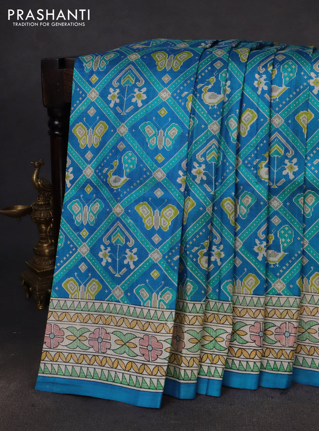 Printed silk saree cs blue and cream with allover patola prints and madhubani printed pallu & border