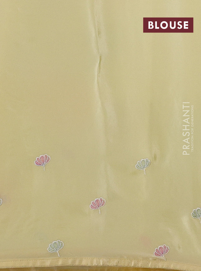 Pure organza silk saree pale yellow with plain body and long floral embroidery border
