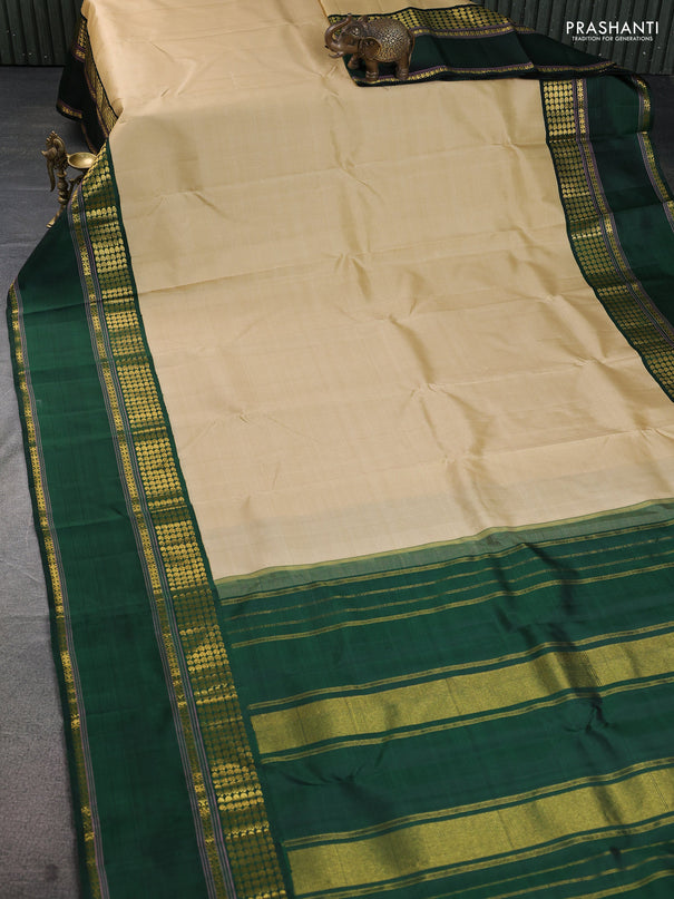 Pure kanchipuram silk saree beige and dark green with plain body and long rettapet zari woven border