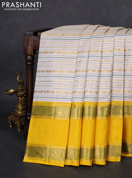 Pure kanchipuram silk saree off white and yellow with allover zari woven rocade weaves and long rettapet zari woven border