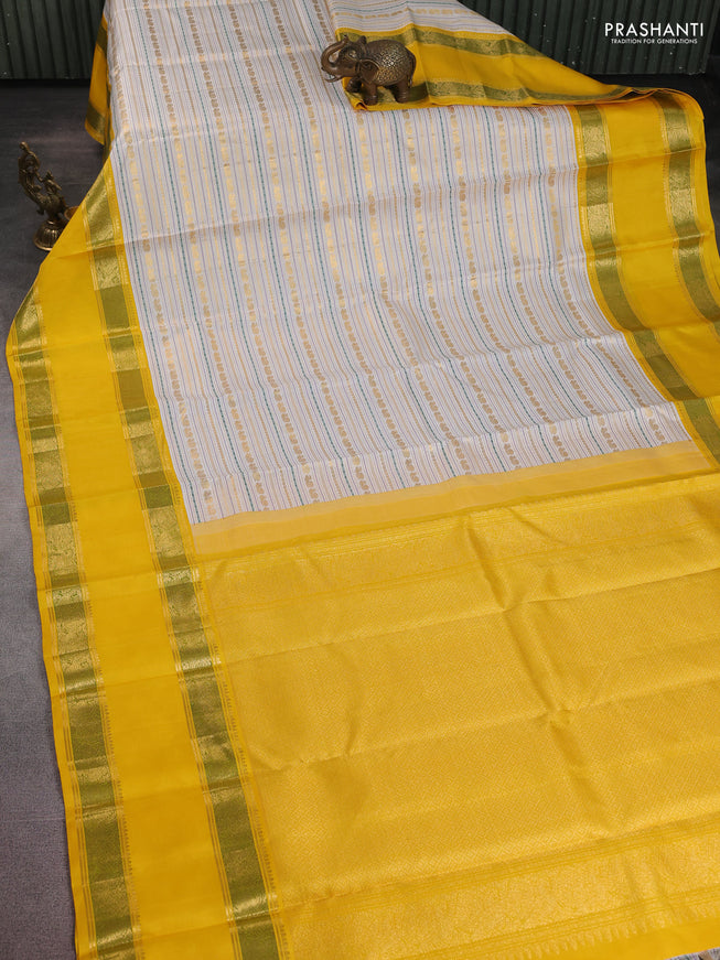 Pure kanchipuram silk saree off white and yellow with allover zari woven rocade weaves and long rettapet zari woven border