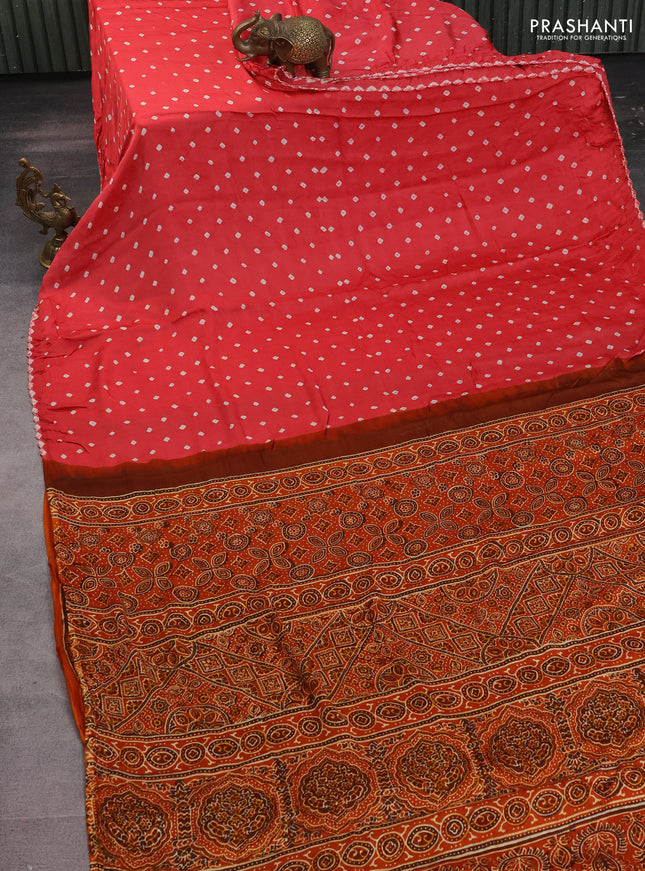 Modal silk saree peach pink and rustic orange with allover bandhani butta prints and ajrakh printed pallu & Blouse