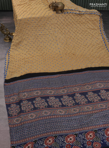 Modal silk saree sandal and peacock blue with allover bandhani butta prints and ajrakh printed pallu & Blouse