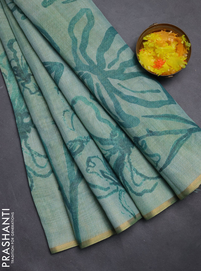 Linen cotton saree teal green with allover prints and zari woven piping border