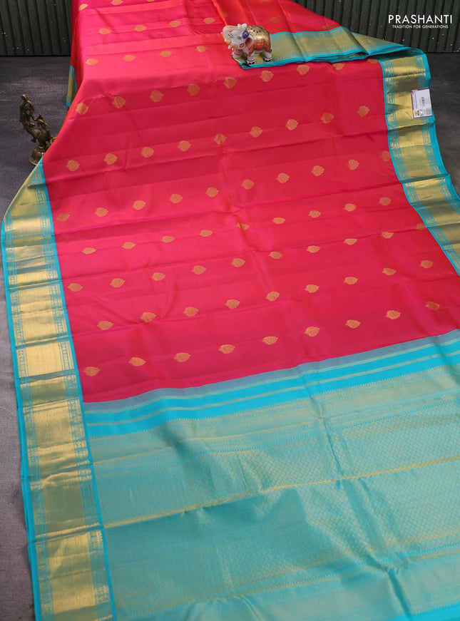 Pure kanchipram silk saree dual shade of pinkish orange and teal blue with zari woven buttas and zari woven korvai border