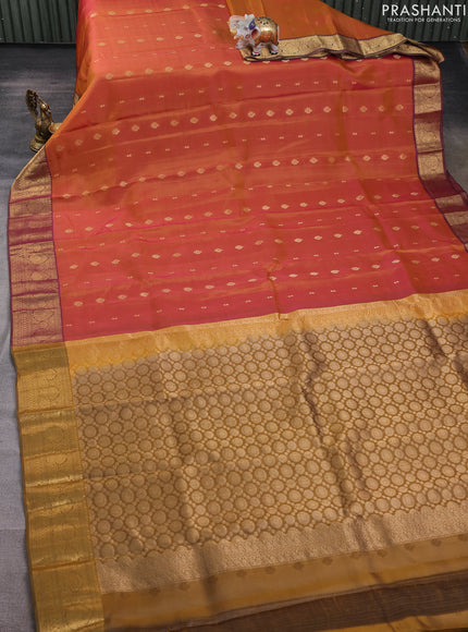 Kanchipuram silk saree dual shade of pinkish orange and dark mustard with allover zari woven buttas and zari woven border