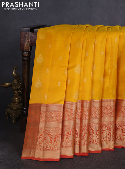 Kanchipuram silk saree yellow and rust shade with allover zari woven buttas and long zari woven border