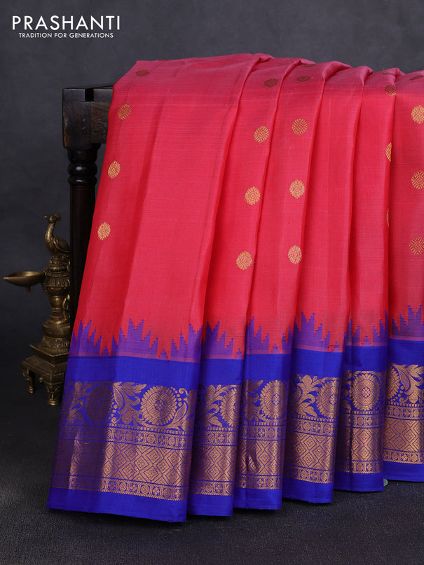 Pure gadwal silk saree tomato pink and blue with allover zari woven buttas and temple design zari woven border