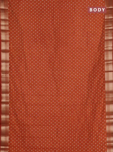 Semi raw silk saree rust shade with allover butta prints and zari woven border
