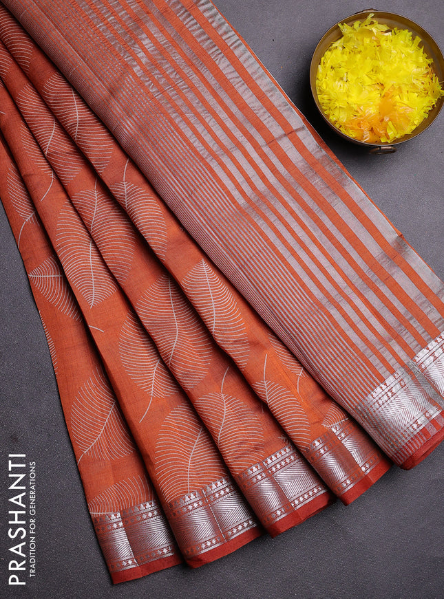 Semi raw silk saree rust shade with allover leaf butta prints and zari woven border