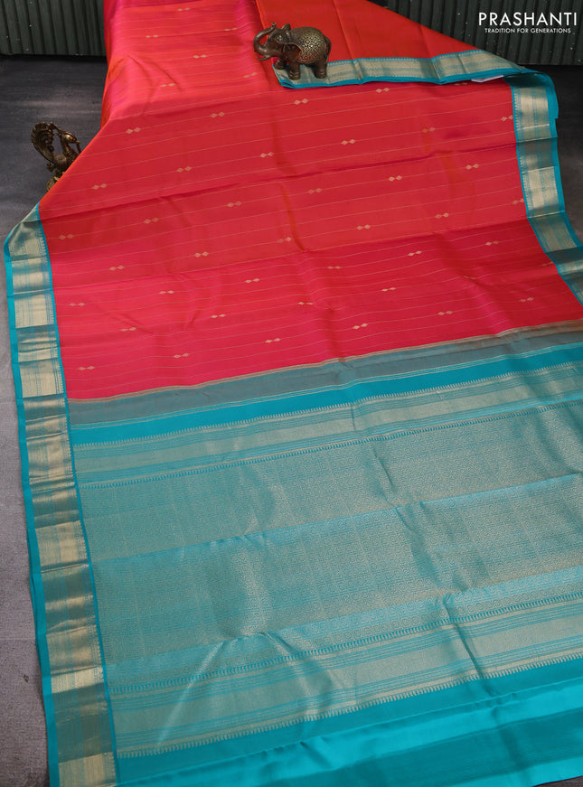 Pure kanchipuram silk saree dual shade of pinkish orange and teal blue with allover zari stripe pattern & buttas and zari woven korvai border