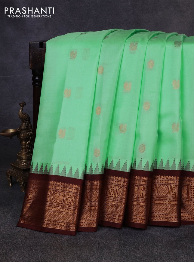 Pure gadwal silk saree pista green and coffee brown with allover annam zari woven buttas and temple design zari woven border