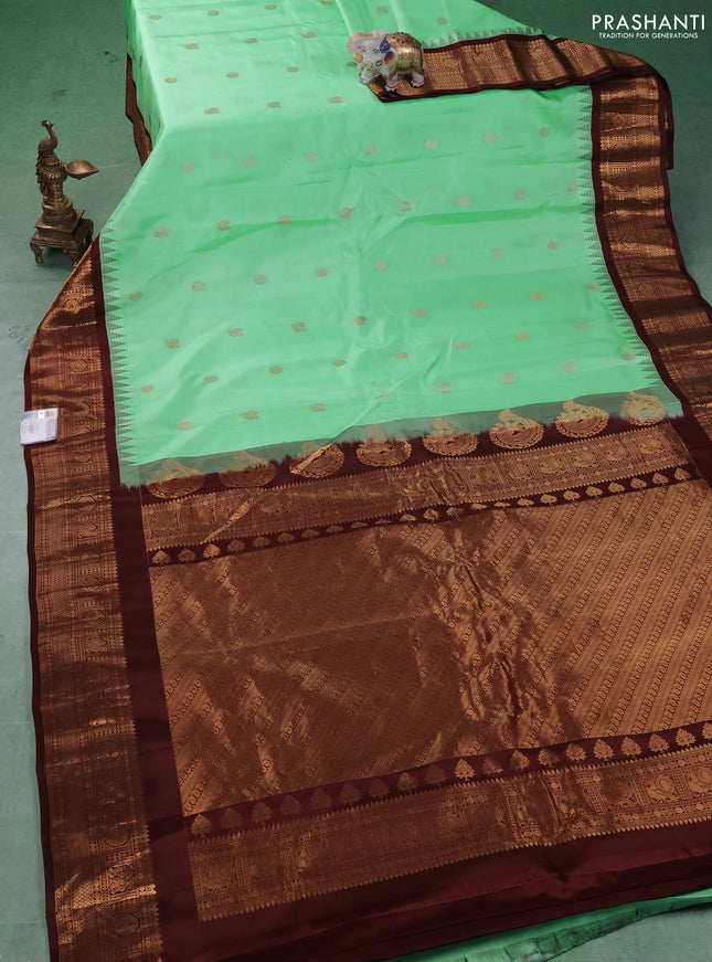 Pure gadwal silk saree pista green and coffee brown with allover annam zari woven buttas and temple design zari woven border