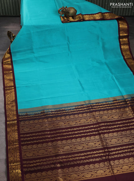 Silk cotton saree teal blue and deep maroon with plain body and zari woven korvai border
