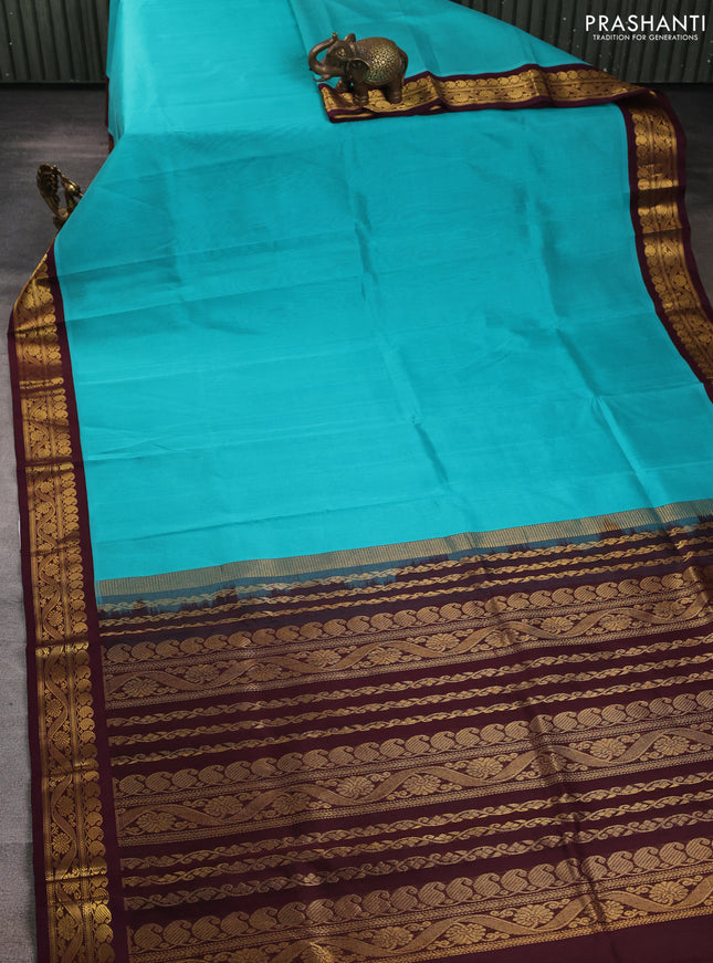 Silk cotton saree teal blue and deep maroon with plain body and zari woven korvai border