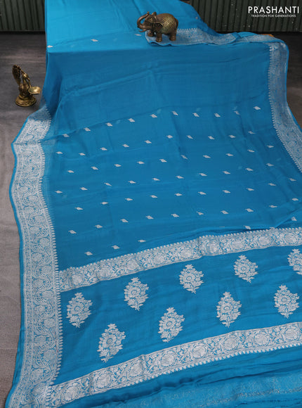 Banarasi chiffon saree teal blue with allover silver zari woven buttas and silver zari woven floral border