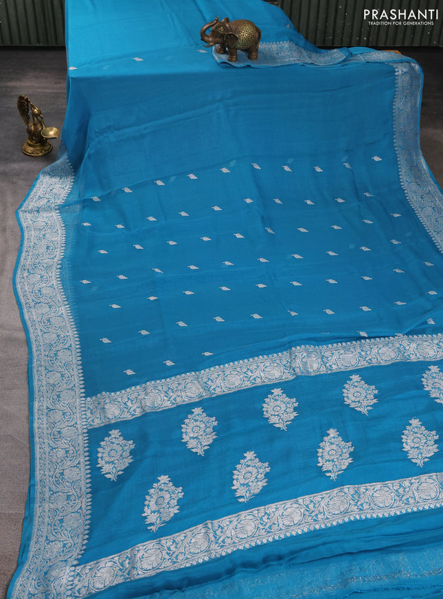 Banarasi chiffon saree teal blue with allover silver zari woven buttas and silver zari woven floral border