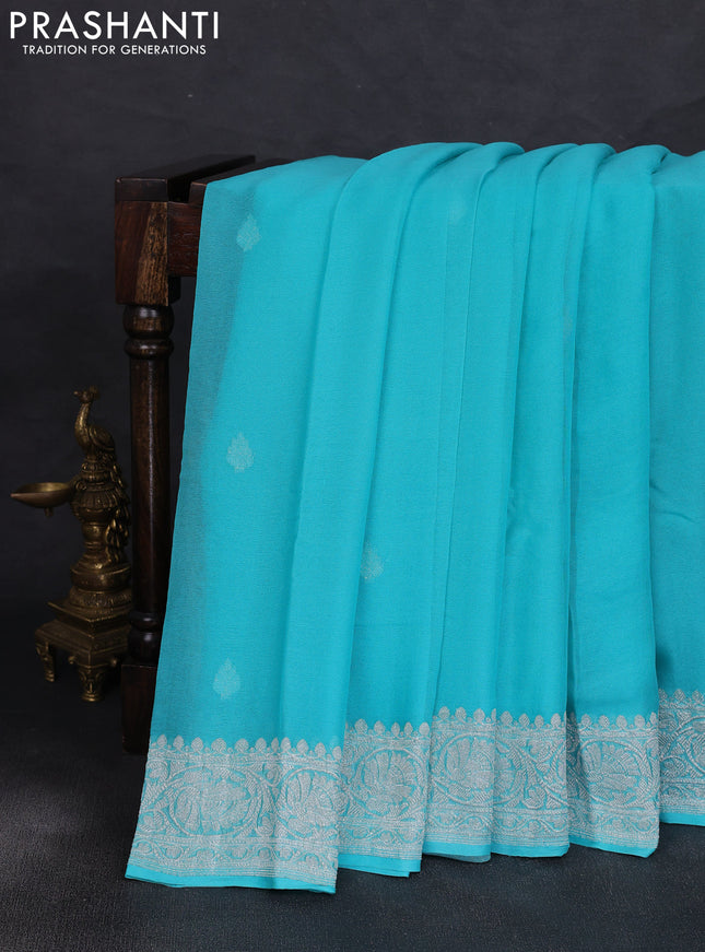 Banarasi chiffon saree teal blue with allover silver zari woven buttas and silver zari woven floral border