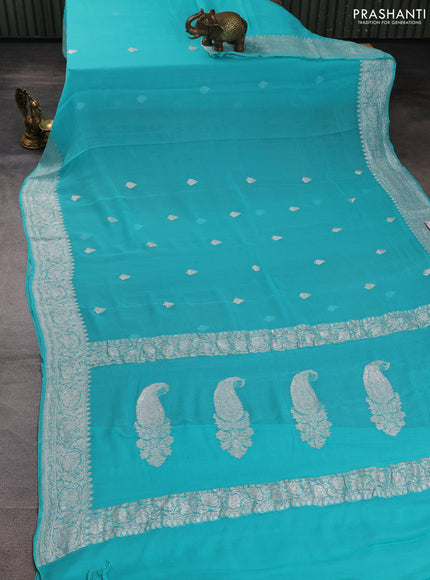 Banarasi chiffon saree teal blue with allover silver zari woven buttas and silver zari woven floral border