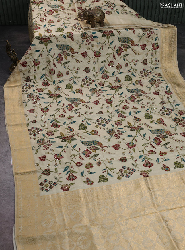Crepe silk saree cream with allover prints & pita embroidery work and zari woven border