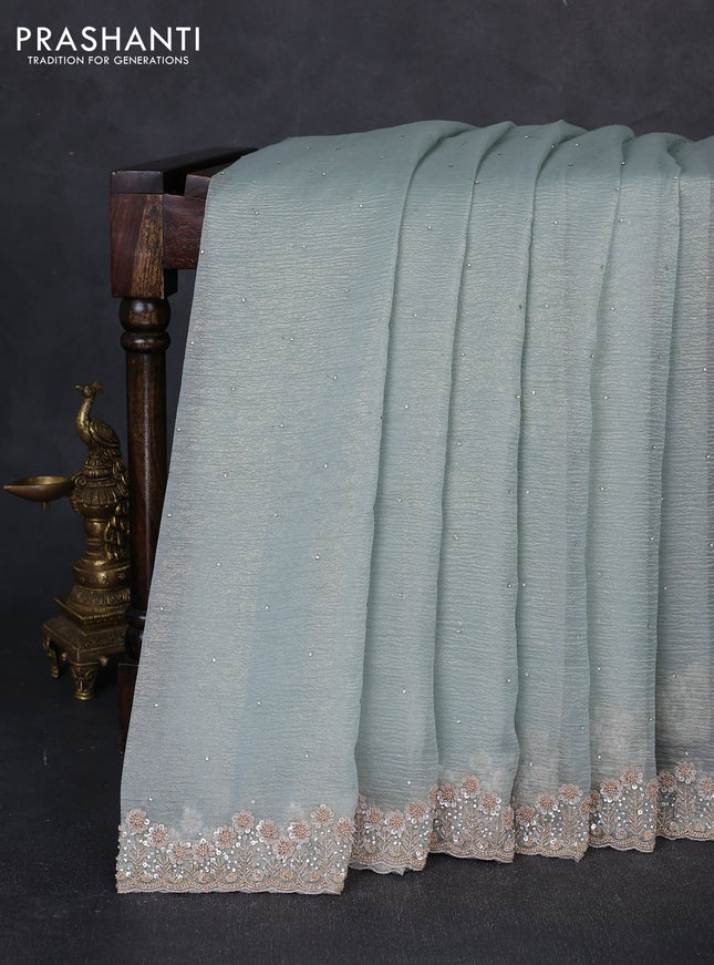 Crush tissue saree pastel green shade with allover stone work and sequin embroidery pallu & border