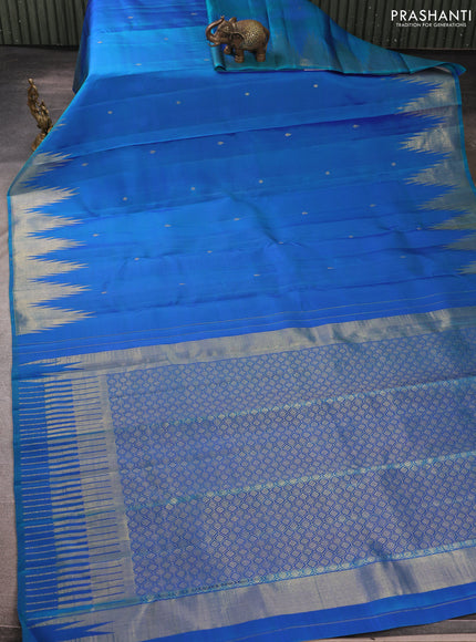 Pure kanchipurams silk saree dual shade of bluish green and purple with zari woven buttas and temple design zari woven border