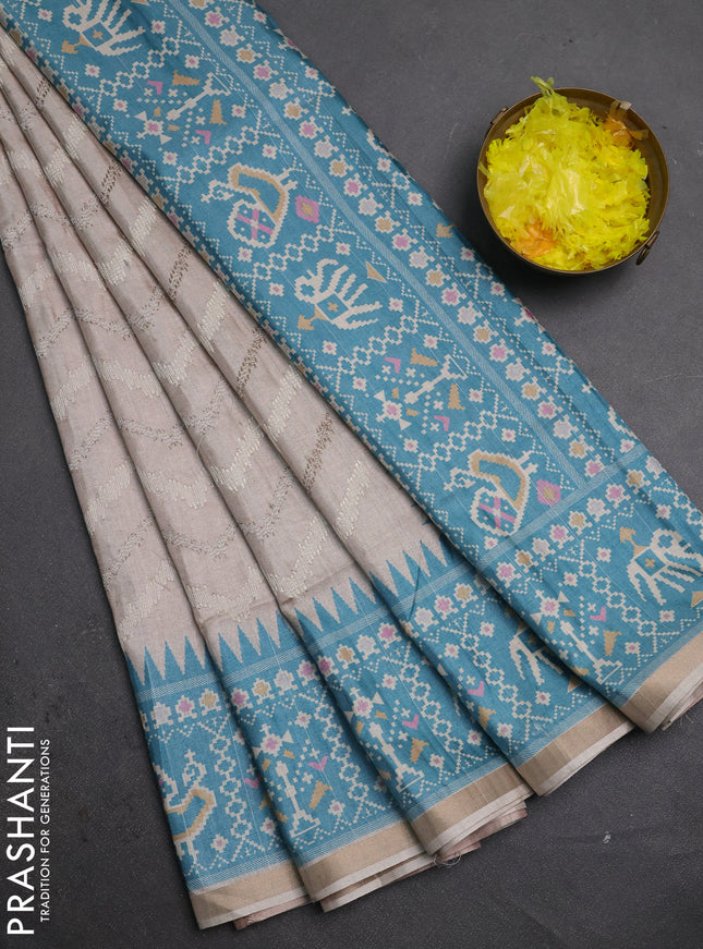 Art tussar saree beige and teal green shade with allover embroidery work and patola printed border