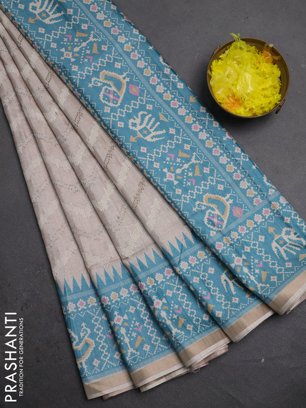 Art tussar saree beige and teal green shade with allover embroidery work and patola printed border