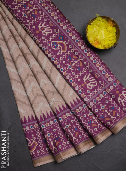Art tussar saree beige and purple with allover embroidery work and patola printed border