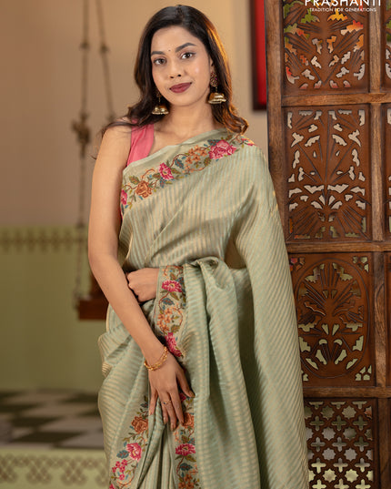 Tissue saree pastel green with allover zari stripe pattern and embroidery border