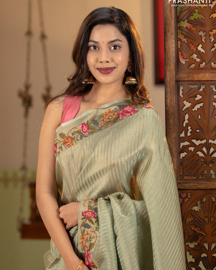 Tissue saree pastel green with allover zari stripe pattern and embroidery border