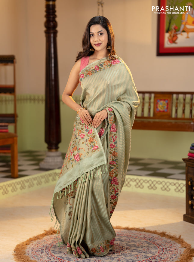 Tissue saree pastel green with allover zari stripe pattern and embroidery border